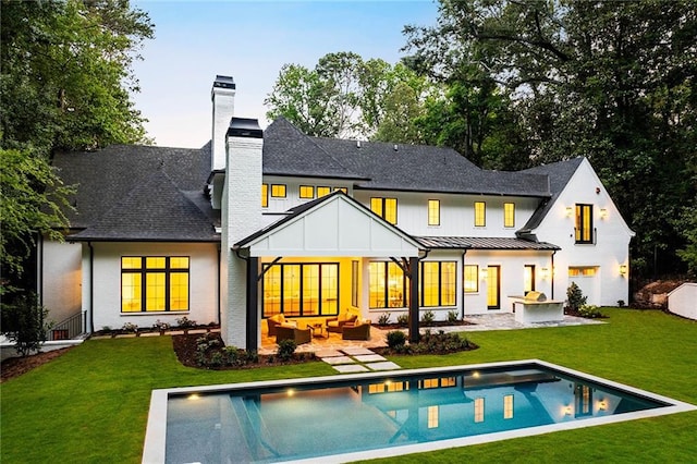 rear view of house featuring outdoor lounge area, a yard, and a patio area