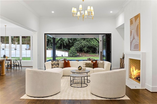 living room featuring dark wood-type flooring, an inviting chandelier, and ornamental molding