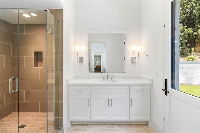 bathroom featuring vanity and a shower with door