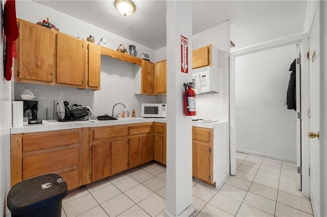 kitchen with tasteful backsplash, sink, and light tile patterned floors