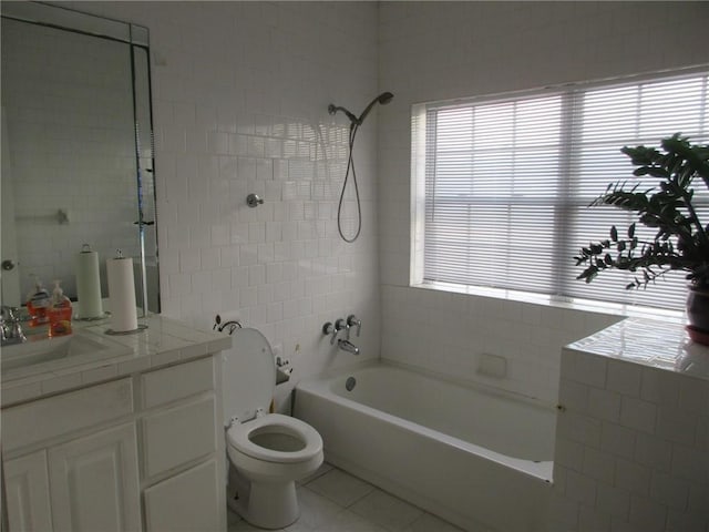 full bathroom with tiled shower / bath, tile walls, vanity, toilet, and tile patterned floors