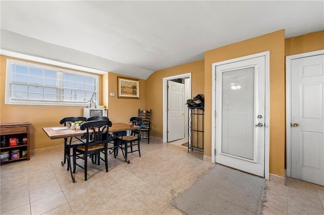 dining space featuring vaulted ceiling