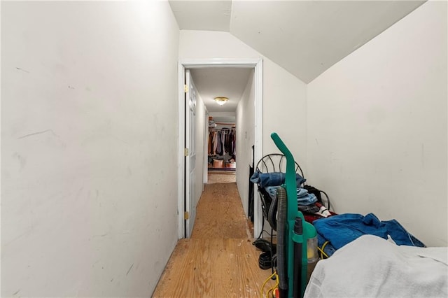 hall with lofted ceiling and light hardwood / wood-style floors