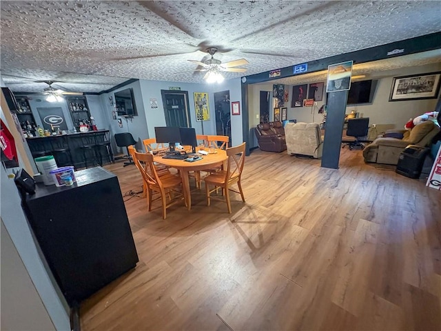 dining space with a ceiling fan and wood finished floors