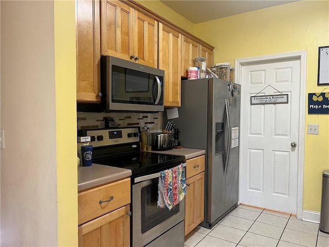 kitchen featuring light countertops, stainless steel appliances, and light tile patterned floors