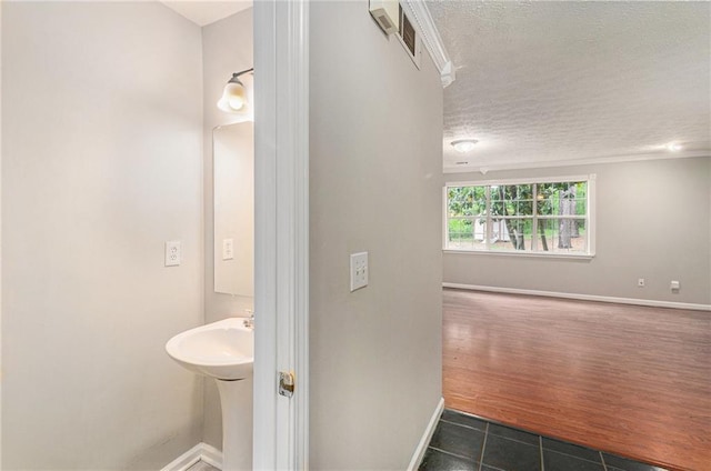 bathroom with baseboards, tile patterned floors, a textured ceiling, and visible vents