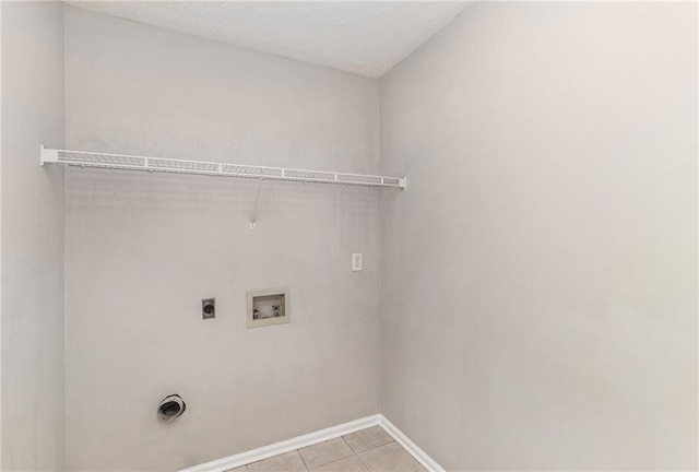 washroom with hookup for an electric dryer, laundry area, light tile patterned floors, baseboards, and hookup for a washing machine