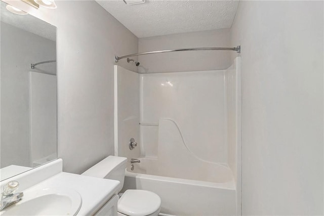 bathroom with vanity, a textured ceiling, shower / bath combination, and toilet