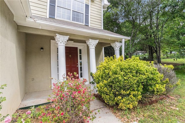view of exterior entry featuring stucco siding and a porch