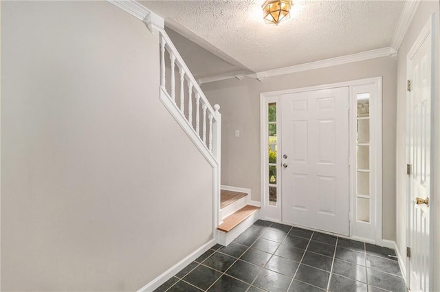entrance foyer with a textured ceiling, stairs, baseboards, dark tile patterned floors, and ornamental molding