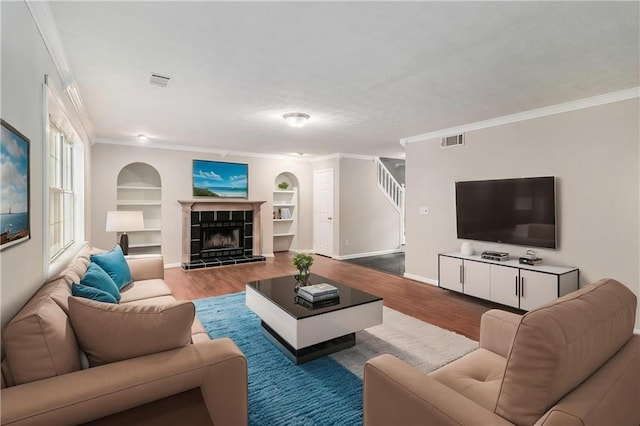 living room featuring visible vents, crown molding, and wood finished floors
