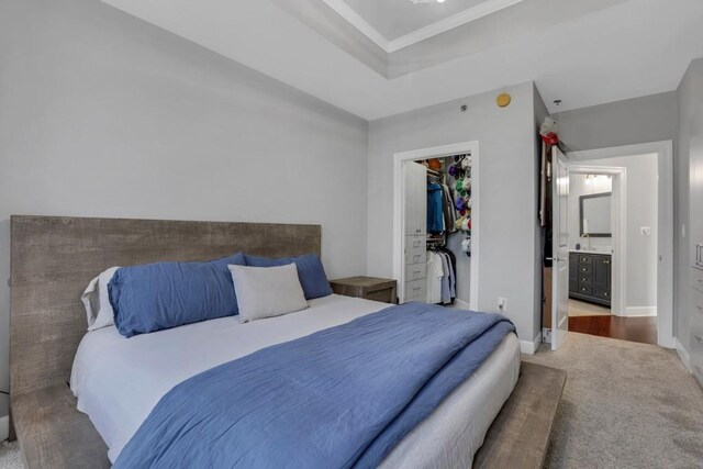 325 E Paces Ferry Rd NE Unit 1910, Atlanta, GA 30305 - bedroom featuring a spacious closet, carpet floors, a closet, crown molding, and a raised ceiling