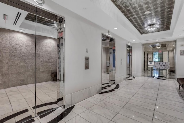 325 E Paces Ferry Rd NE Unit 1910, Atlanta, GA 30305 - hallway featuring a raised ceiling, marble finish floors, recessed lighting, and elevator