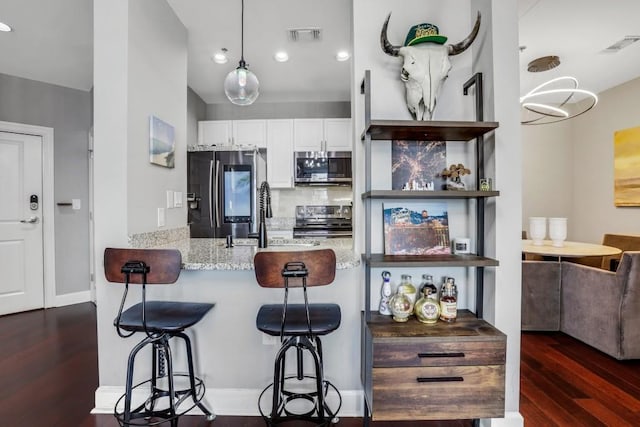 325 E Paces Ferry Rd NE Unit 1910, Atlanta, GA 30305 - kitchen with stainless steel appliances, dark wood finished floors, white cabinets, recessed lighting, and light stone countertops