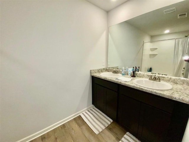 bathroom featuring wood-type flooring, vanity, and walk in shower