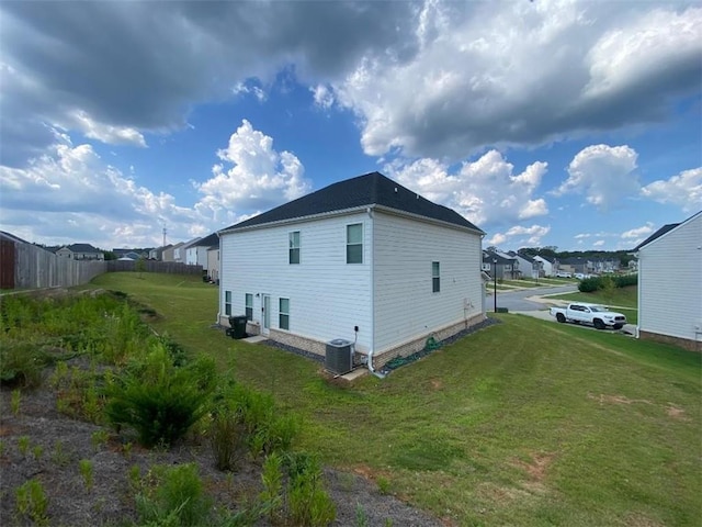 view of property exterior with a yard and central AC