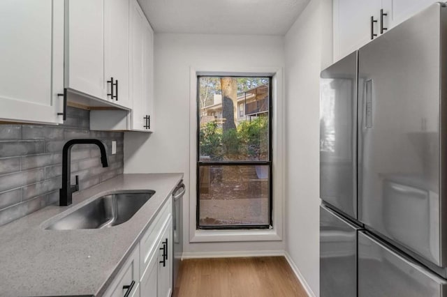 kitchen with white cabinets, appliances with stainless steel finishes, and a sink