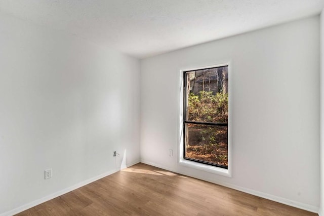 empty room featuring wood finished floors and baseboards