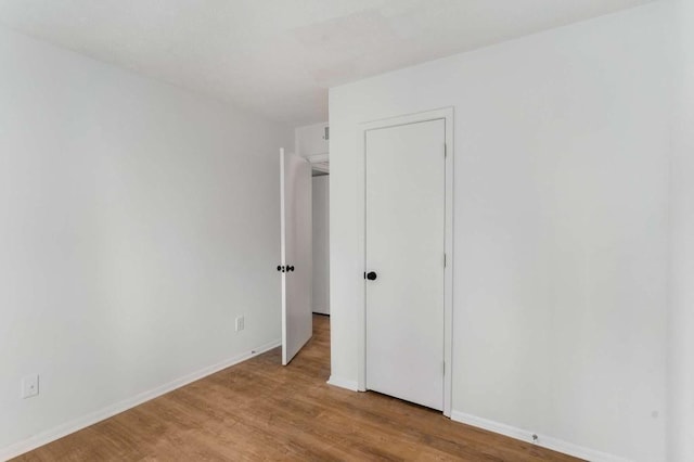 unfurnished bedroom featuring wood finished floors and baseboards