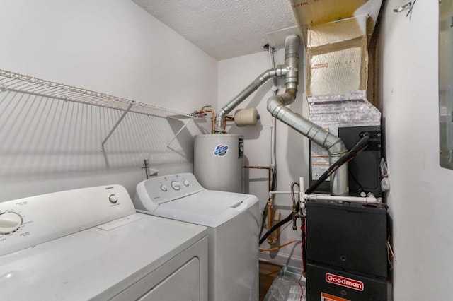 laundry area featuring water heater, laundry area, a textured ceiling, and washer and clothes dryer