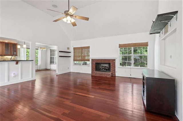 4046 Water Hole Ct, Douglasville, GA 30135 - unfurnished living room with high vaulted ceiling, a ceiling fan, dark wood-type flooring, and a brick fireplace