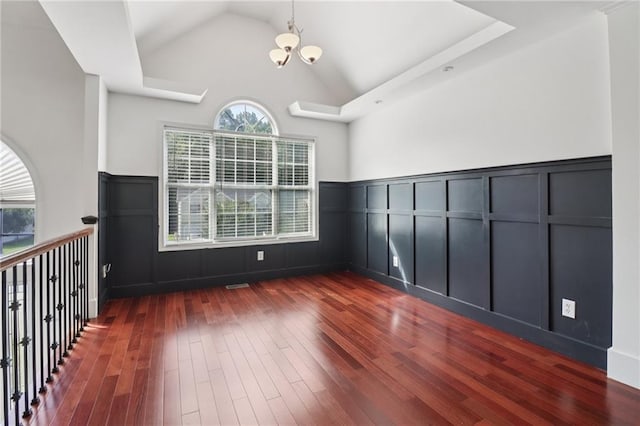 4046 Water Hole Ct, Douglasville, GA 30135 - unfurnished room featuring a decorative wall, a chandelier, dark wood-style flooring, lofted ceiling, and wainscoting