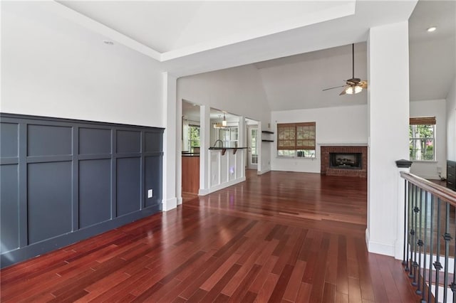 4046 Water Hole Ct, Douglasville, GA 30135 - unfurnished living room with ceiling fan, a fireplace, dark wood-style flooring, a decorative wall, and high vaulted ceiling