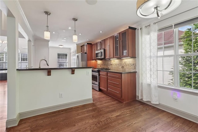 4046 Water Hole Ct, Douglasville, GA 30135 - kitchen featuring stainless steel appliances, dark countertops, a breakfast bar, glass insert cabinets, and brown cabinets