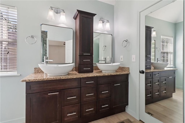 4046 Water Hole Ct, Douglasville, GA 30135 - full bath featuring wood finished floors, double vanity, and healthy amount of natural light