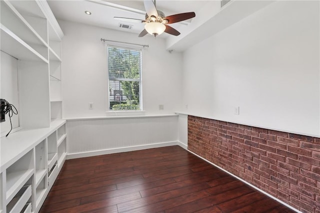 4046 Water Hole Ct, Douglasville, GA 30135 - unfurnished room with wainscoting, dark wood finished floors, a ceiling fan, and brick wall