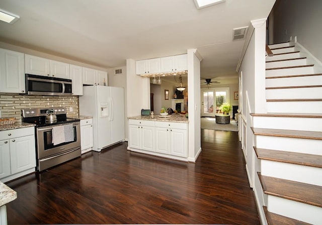 1261 Lavista Rd Unit N4, Atlanta, GA 30324 - kitchen with appliances with stainless steel finishes, white cabinetry, backsplash, dark wood-type flooring, and light stone counters