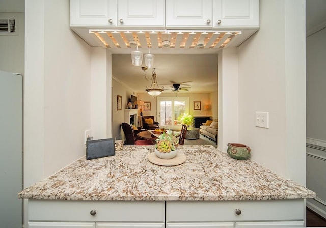 1261 Lavista Rd Unit N4, Atlanta, GA 30324 - kitchen with white cabinets, light stone counters, ceiling fan, open floor plan, and fridge