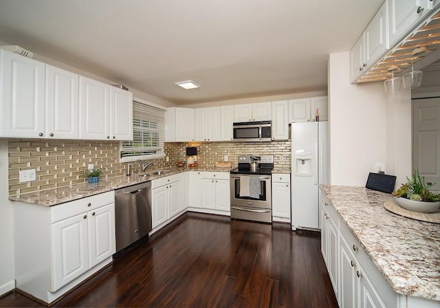 1261 Lavista Rd Unit N4, Atlanta, GA 30324 - kitchen with stainless steel appliances, dark wood finished floors, backsplash, and light stone countertops