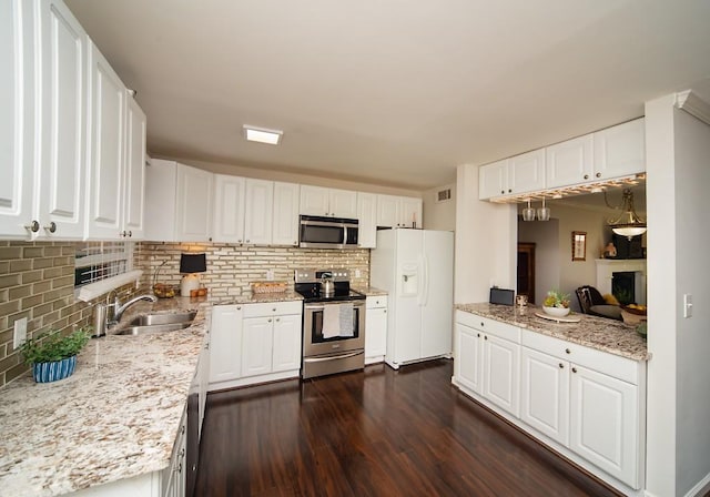 1261 Lavista Rd Unit N4, Atlanta, GA 30324 - kitchen with stainless steel appliances, dark wood-style flooring, backsplash, and white cabinetry