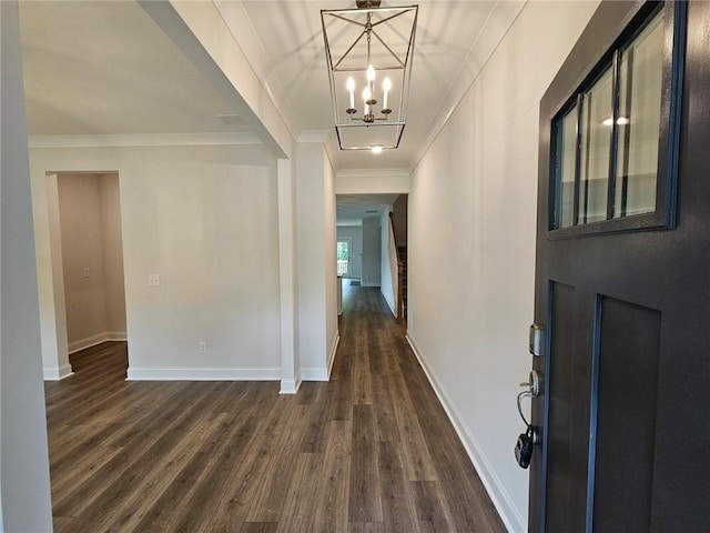 entrance foyer with crown molding, a notable chandelier, and dark hardwood / wood-style floors