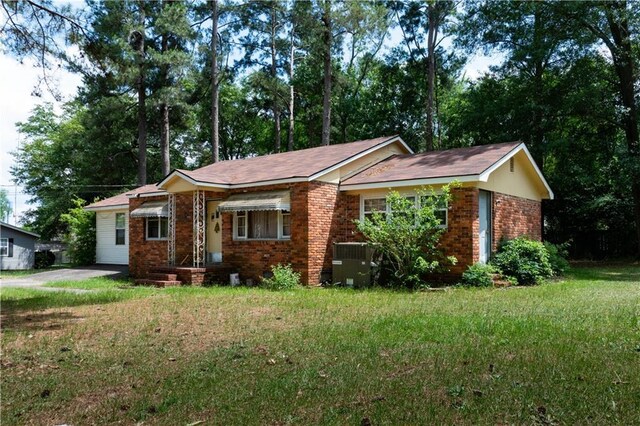 ranch-style house featuring cooling unit and a front yard