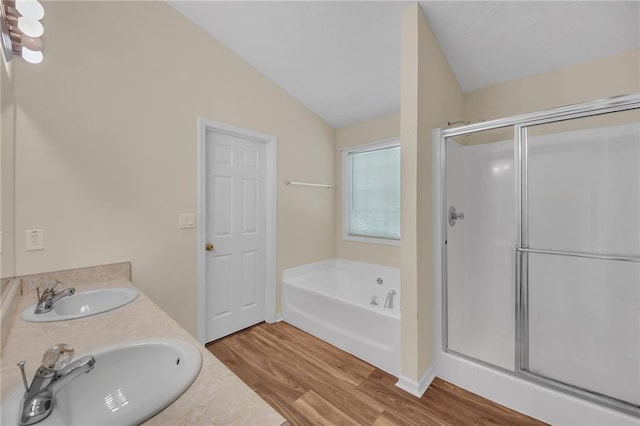 70 Prince Edward Way, Covington, GA 30016 - bathroom with a stall shower, wood finished floors, a bath, double vanity, and vaulted ceiling