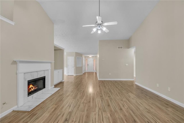 70 Prince Edward Way, Covington, GA 30016 - unfurnished living room featuring a ceiling fan, light wood-style flooring, a high end fireplace, and lofted ceiling