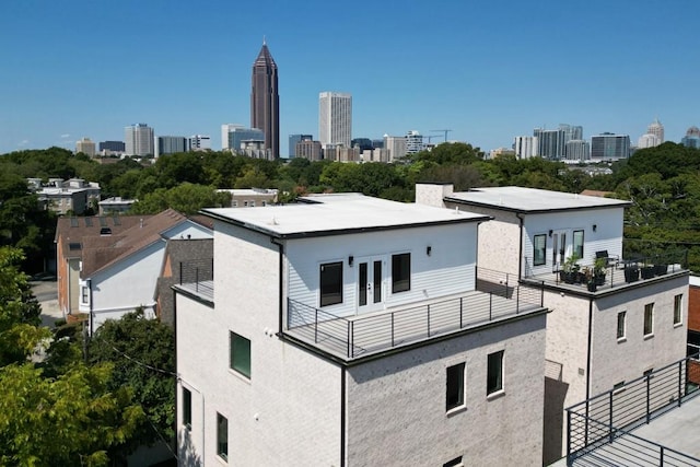 exterior space featuring french doors, a view of city, and a balcony