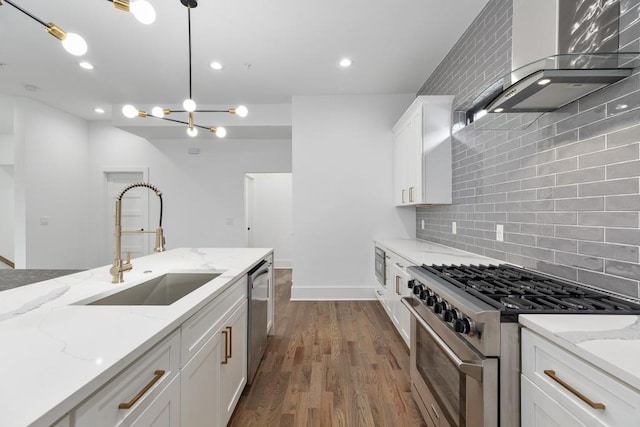 kitchen featuring white cabinets, appliances with stainless steel finishes, a sink, dark wood finished floors, and backsplash