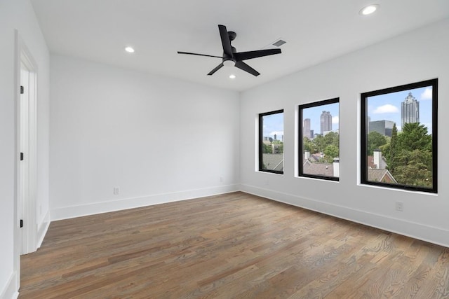 unfurnished room featuring recessed lighting, baseboards, wood finished floors, and visible vents