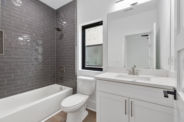 full bathroom featuring visible vents, wood finished floors, vanity, toilet, and tub / shower combination