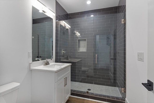 bathroom featuring recessed lighting, vanity, a shower stall, and toilet