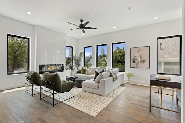 living room with plenty of natural light, a ceiling fan, and wood finished floors