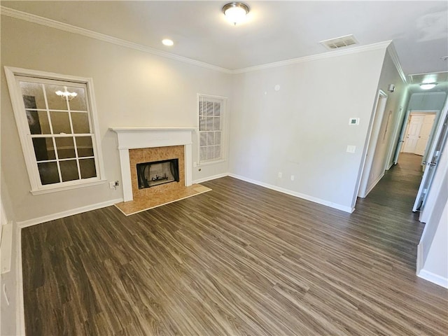 unfurnished living room with visible vents, crown molding, baseboards, a fireplace, and wood finished floors