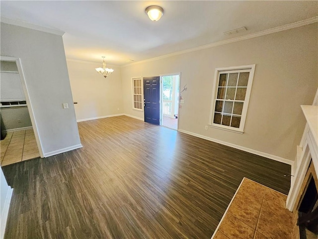 unfurnished living room with wood finished floors, baseboards, a fireplace, ornamental molding, and a notable chandelier