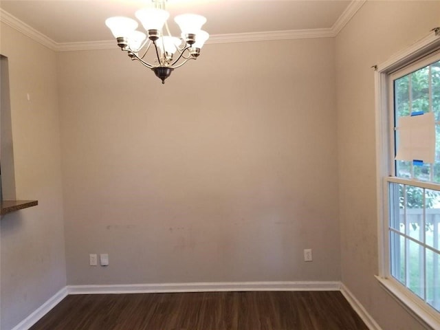 spare room with dark wood-style floors, baseboards, an inviting chandelier, and ornamental molding