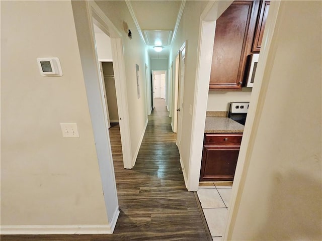 hall featuring baseboards, attic access, dark wood finished floors, and crown molding