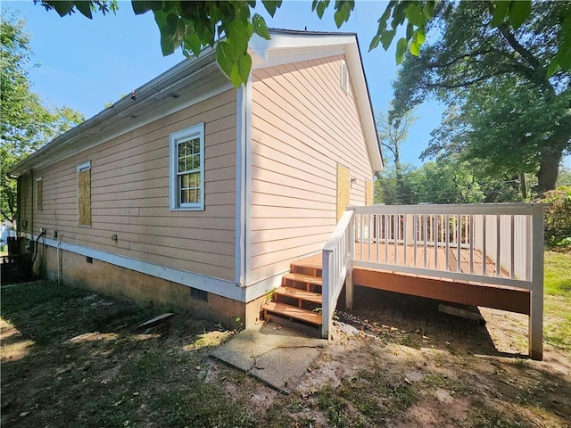 view of side of property featuring a wooden deck and crawl space