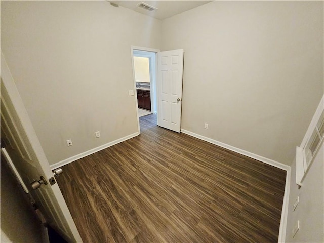 unfurnished bedroom with baseboards, visible vents, and dark wood-style flooring